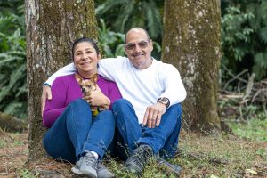 a man and woman sitting next to each other with a senior chihuahuas
