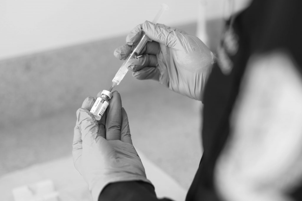 a person holding a syringe and a needle